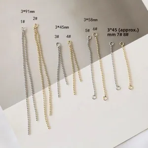 Dettaglio dei connettori a catena con nappa in oro e argento per creazione gioielli DIY