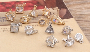 Macro detail of geometric metal pendants with zircon insets for DIY jewelry making