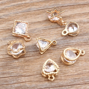 Detailed view of DIY geometric pendants with inlaid zircons on a rustic wooden background