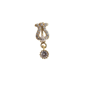 Golden harp-style jewelry piece with sparkling zircons on white background