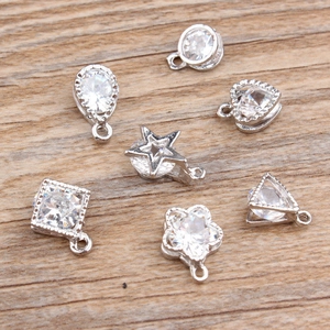 Macro shot of silver metal DIY charms in various shapes with clear zircon inlays