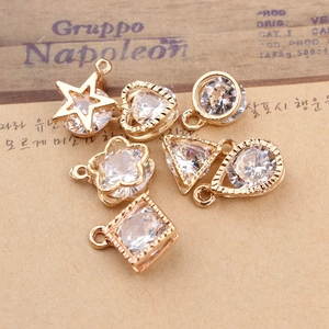 Macro shot of six gold-plated geometric pendants with sparkling cubic zirconia inlays