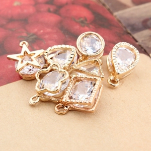Macro shot of gold geometric charms featuring inlaid zircon crystals in various shapes