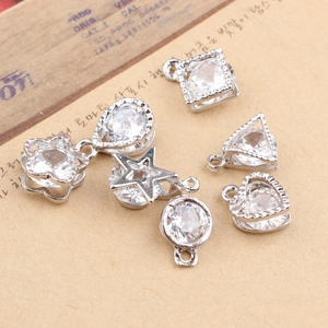 DIY jewelry pendants set with clear zircon stones in geometric shapes on vintage background