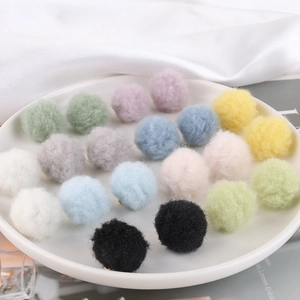 Macro view of colorful plush pom-pom earrings with soft texture and metal studs
