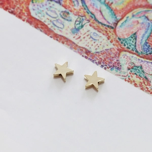 Boucles d'oreilles étoiles dorées 14 carats polies avec un design en métal minimaliste