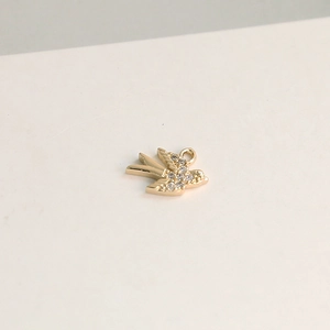 Vue macro de pendentif oiseau doré avec cristaux sertis et anneau de suspension