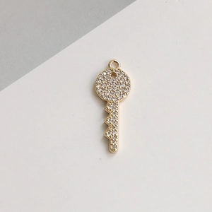 Macro d'un pendentif clé plaqué or serti de zircons blancs pour bijoux faits main