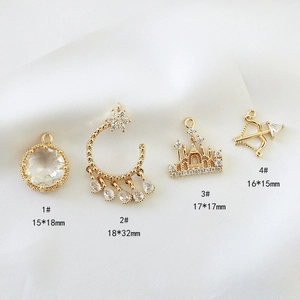 Detail of four gold pendants with zircon: castle, bow, and moon shapes with measurements