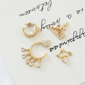 Detailed view of four vintage gold-plated jewelry pendants with sparkling zircon stones