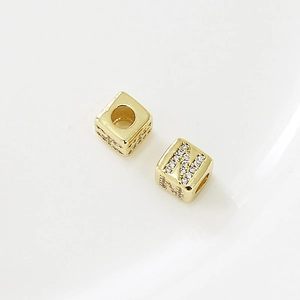 Dettaglio di perline quadrate dorate con lettera N in zircone per gioielli fai da te
