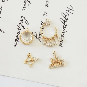 Detailed view of vintage gold-plated pendants including castle, bow, and zircon stones