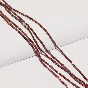 Macro view of multi-strand iridescent metallic red faceted glass beads for jewelry
