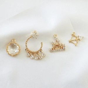 Vintage gold-plated jewelry pendants featuring castle, bow, crescent, and zircon stones