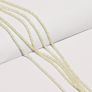 Close-up of faceted light yellow crystal wheel beads for DIY jewelry making and necklaces