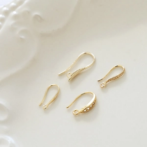 Detalle macro de ganchos para pendientes chapados en oro 18k con circonitas para joyería