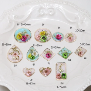 Detail showing 11 geometric resin pendants with real dried flowers and gold flakes