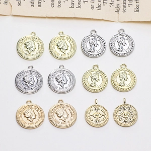 Vintage gouden en zilveren muntbedels met koninginportretten en zon-oogmotieven op wit