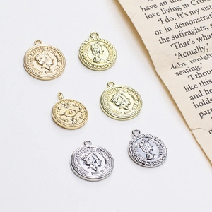 Platliggende vintage goud- en zilvermuntbedels met koninginportret en boze oogmotieven
