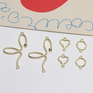 Pendentifs dorés en forme de cœur et papillon pour création de bijoux DIY sur blanc
