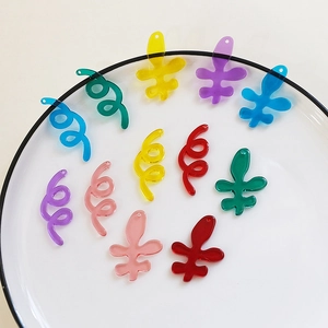 Macro shot of colorful translucent acrylic tulip flower and spiral charms for DIY jewelry