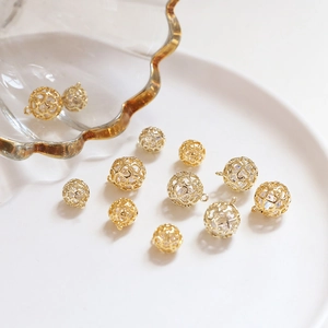 Dettaglio di sfere cave in oro 18k con cuori e cristalli per gioielli fai da te