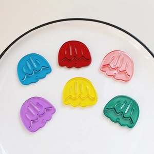 Detailed close-up of colorful translucent jellyfish acrylic pendants in a ceramic plate
