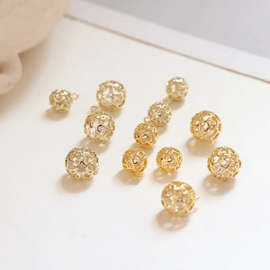 Dettaglio di ciondoli a sfera cavi placcati in oro 18k per la creazione di gioielli DIY