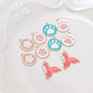Detail of alloy enamel flower, paw, and mermaid tail pendants for DIY jewelry making
