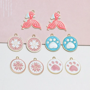 Detailed view of DIY enamel alloy charms featuring fish tails, flowers, and paw prints