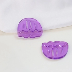 Close-up of translucent purple jellyfish-shaped acrylic charms for DIY earring making