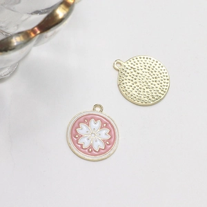 Detail of pink enamel cherry blossom charms with gold trim for DIY jewelry making