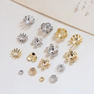 Makro-Detail von vergoldeten und versilberten Blumen-Perlenkappen für DIY-Schmuck