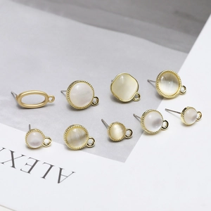 Close-up of golden metal cat eye stone earring settings with side loops for DIY jewelry