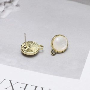 Macro detail of 925 silver cat eye stone earrings with gold metal beaded edge and DIY loops