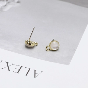 Detail of gold metal earring component with white opal stone and side connection ring