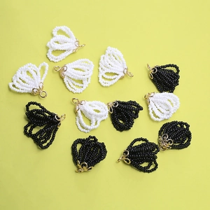 Macro shot of fan-shaped beaded pendants with intricate golden hollow metal flower caps