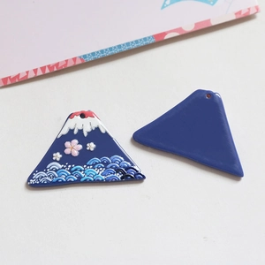 Detalle de colgantes de esmalte del Monte Fuji y flores de cerezo para joyería artesanal