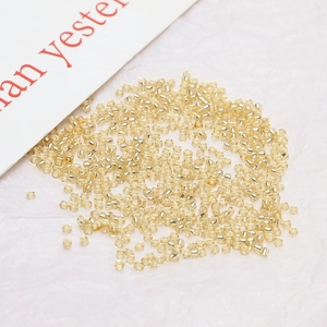Macro view of 2mm champagne gold silver-lined glass seed beads for DIY jewelry making