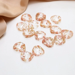Détail de breloques en résine avec feuilles d'or pour la création de bijoux DIY à la main