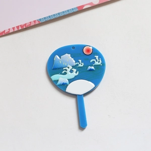 Detalle del colgante de acrílico azul en forma de abanico con motivos japoneses