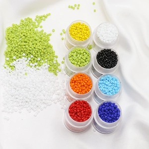 Macro view of 2mm porcelain seed beads in 8 bright colors stored in clear plastic boxes