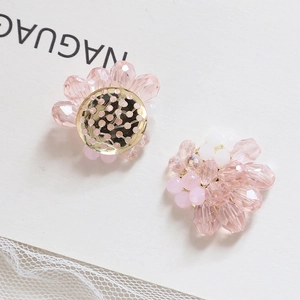 Detailed view of handmade pink and white flower-shaped crystal beads with gold metal base