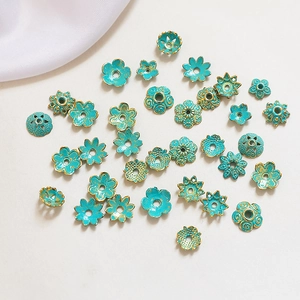 Detailed flat lay of blue enamel flower bead caps with gold gilding for DIY jewelry making