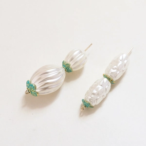 Detailed macro view of vintage pearl beads with gold-trimmed blue enamel flower caps