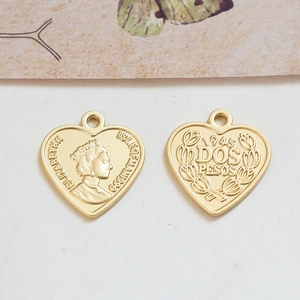 Detailansicht goldener Herzanhänger mit Vintage-Münzprofilen und gravierten Schriften