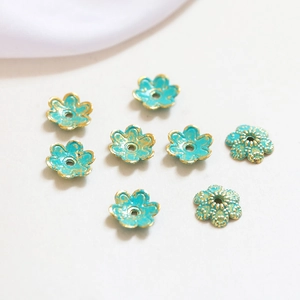 Detailed view of eight blue enamel and gold flower beads for DIY jewelry making