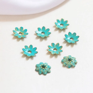Macro detail of turquoise flower bead caps with gold gilding for DIY jewelry making