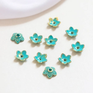 Detail of turquoise flower bead spacers with gold edges for DIY jewelry making