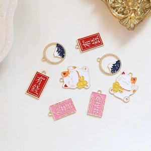 Detail van verzilverde Maneki Neko bedeltjes met kleurrijk emaille voor DIY-sieraden